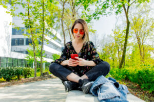 A woman sitting on the ground using her mobile phone