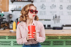 Woman drinking a soda | Enjoy unlimited soda with the Bottomless Bubbles drink package