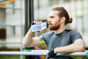 Man drinking water on the deck of a cruise ship