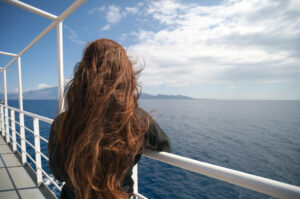 Woman standing at a cruise ship railing.